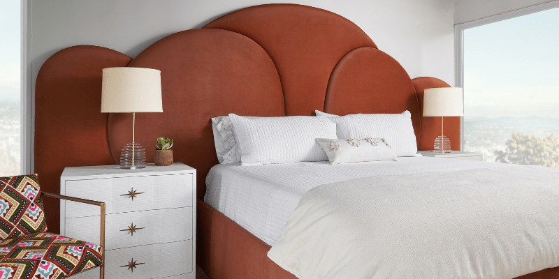 Rust-colored upholstered bed that has a very 80's vibe